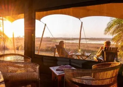 couple sitting on desk of busanga plains camp site