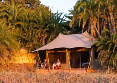 couple sitting on desk of busanga plains camp site